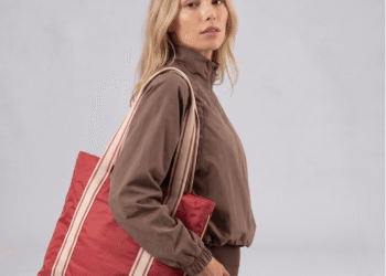 Mulher loira com roupa de academia e bolsa vermelha