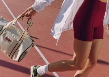 Mulher com roupa vermelha segurando bolsa na mão